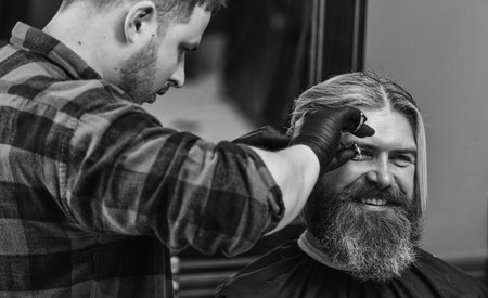 hair cut and beard care for caucasian guy in barbershop, occupationの写真素材
