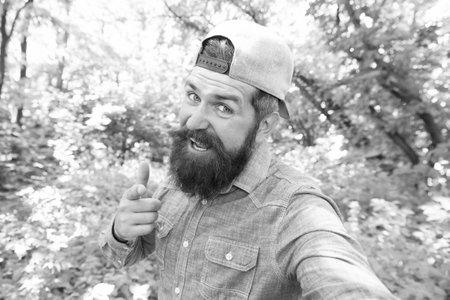 summer day rest in nature. hiking in forest. concept of hiker lifestyle. cheerful man making selfie.の写真素材