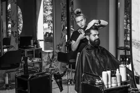 Portrait of stylish guy and Barber master with scissors and brush, barbershopの写真素材