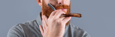 cropped view of man in barber studio. man hold barber blade for shaving. man shaving with bladeの写真素材