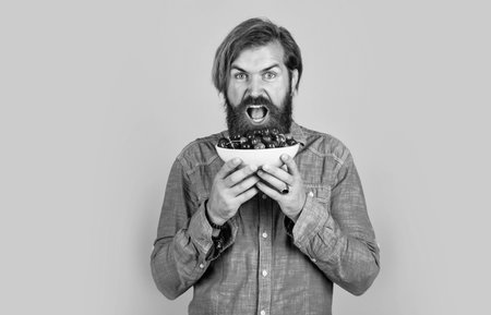 brutal bearded male man hold cherry berry, natural foodの写真素材