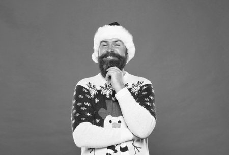 So pleased. happy new year. merry christmas. cheerful bearded man in santa hat and sweater. brutal hipster celebrate xmas party. winter holiday preparations. male winter knitwear fashionの写真素材