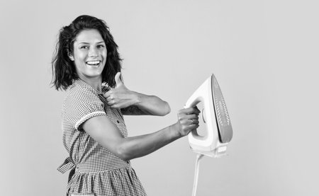 best quality. steaming iron. pinup girl prepare ironing. vintage lady hold modern iron. Everyday life housework. retro woman with iron. happy housekeeper ironing. concept of householding. copy spaceの写真素材