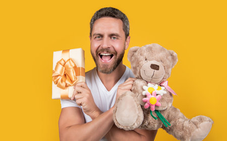 man laugh hold valentine present isolated on yellow background. man hold valentine presentの写真素材