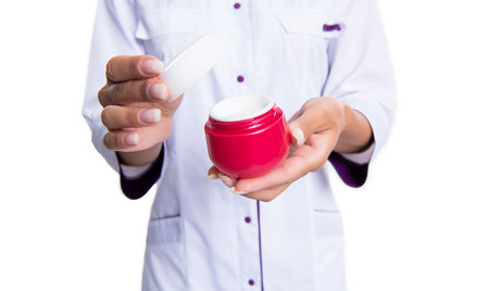photo of moisturizer cream jar in hands of cosmetologist. moisturizer for skincare.の写真素材