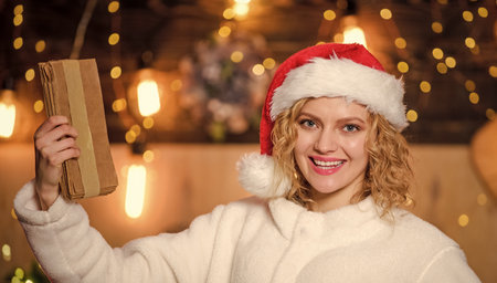 woman hold parcel. write wish list. letter to santa. family greeting with holidays. christmas party invitation. happy new year. merry christmas. xmas presents. woman in santa hatの写真素材
