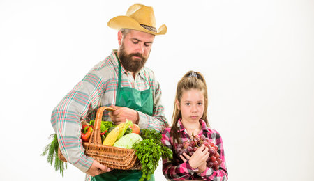 Gardening and harvesting. Family farm organic vegetables. Man bearded rustic farmer with kid. Farmers family homegrown harvest. Father farmer or gardener with daughter hold basket harvest vegetablesの写真素材