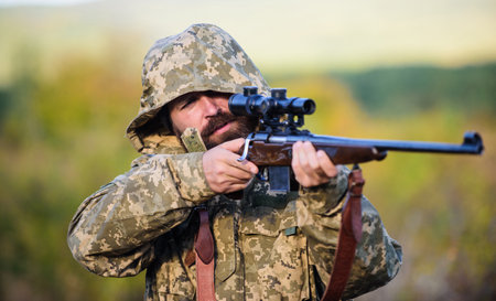 Hunting season. Guy hunting nature environment. Bearded hunter rifle nature background. Experience...