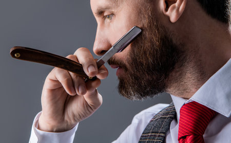 closeup of man barbering in barbershop studio. bearded man at barbershop. unshaven manの写真素材