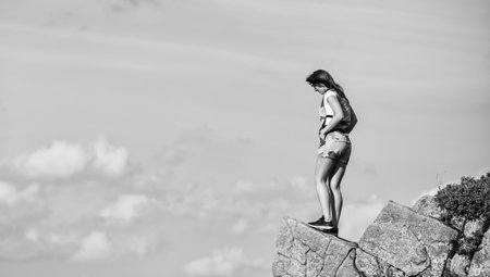 achieve success. way to success. jump into abyss. mountain traveling and hiking. climbing skill. mountaineering lover. reaching the top. woman stand on mountain cliff. feel freedom. extremely freeの写真素材