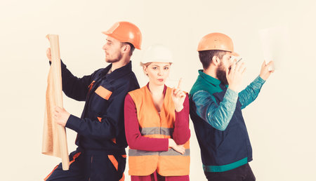 Men and woman in helmets carefree with hammer and project,