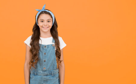Cute small kid fashion girl. Fashion accessories. Summer outfit concept. Girl long curly hair. Fashion trend. Little fashionista. Happy childhood. Modern teen clothing. Accessory shop. Positive vibesの写真素材