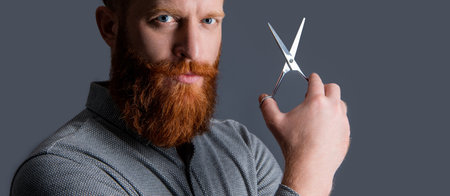 barber man portrait in hairdresser studio. barber man hold scissors for hairdressing.の写真素材