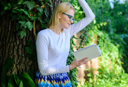Bookworm student relaxing with book green nature background. Literature as hobby. Spend leisure with...