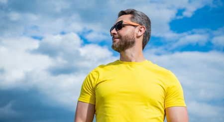 guy in yellow shirt and sunglasses outdoor on sky background. copy spaceの写真素材