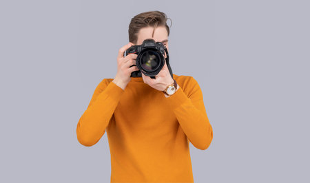 man photographer taking picture with camera isolated on grey background. man photographer
