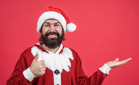 Christmas is coming. present and gift shopping sale. happy new year. merry christmas. cheerful bearded man in santa claus costume. brutal hipster celebrate xmas party. winter holiday preparationsの写真素材