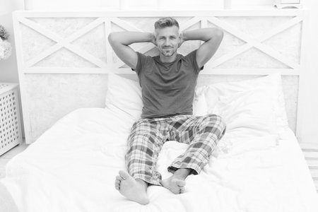 Wake up and smile. Happy man in pajamas relax in bed. Waking up in morning. Morning vibesの写真素材