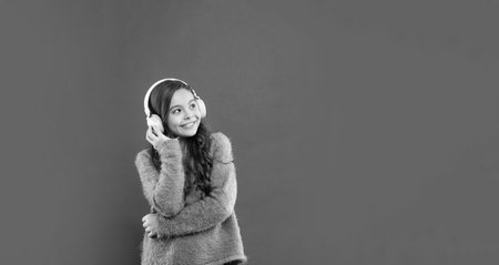 happy child listen music in headphones. kid wear sweater. express positive emotion.の写真素材