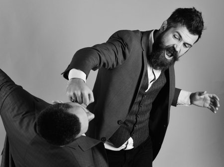 Businessman wearing smart suit punches or hits colleague.