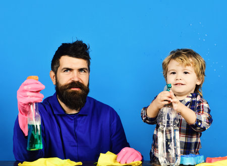 Kid with father holds cleaning sprays on blue background