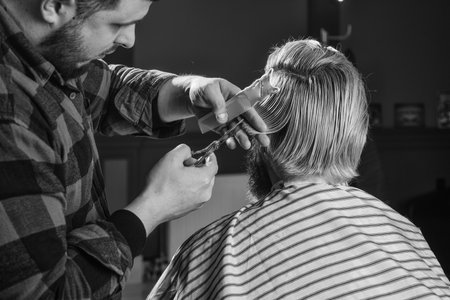 Male barber care. professional barber with male client. hipster with dyed beard and moustache. man want new hairstyle. male beauty and fashion. mature man at barbershop. man at hairdresserの写真素材