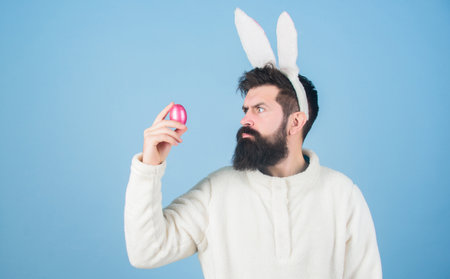 Grinning bearded man wear silly bunny ears. Easter symbol concept. Hipster cute bunny long ears blue background. Easter bunny. Having fun. Funny bunny with beard and mustache. Join celebrationの写真素材