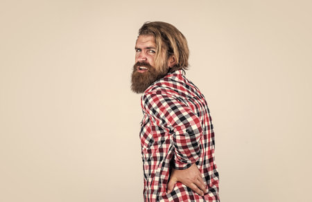 This is a terrible pain. brutal bearded hipster has unhealthy kidney. male feel pain in back. casual male need medical care. Handsome bearded man in casual clothes. Suffering Caucasian Manの写真素材