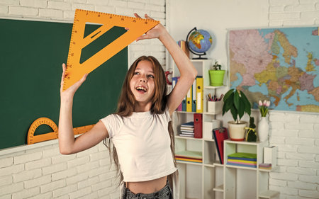teen girl with triangle ruler. back to school. concept of education. measuring angle degree.の写真素材