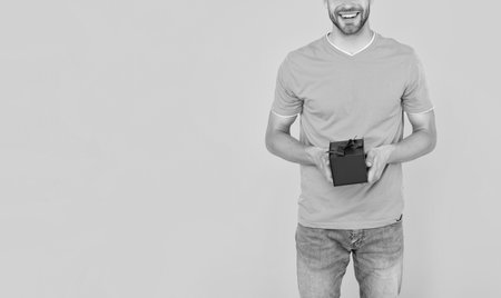 cropped guy hold gift box on yellow background with copy space, boxing day