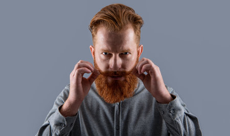 Portrait of Irish man with beard. Serious man twirling moustache. Bearded man with unshaven face
