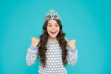 Happiness and success. Lady small baby princess. Number one. Kid wear golden crown symbol of princess. Girl cute baby wear crown blue background. So pleased. Princess concept. Girl princessの写真素材