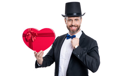 glad tuxedo man hold valentine day box. man in tuxedo holding gift for valentine day. tuxedo man