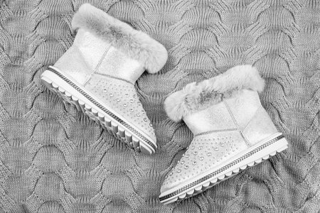 pair of fashionable leather ugg boots. ankle boots on knitted background. shoe storeの写真素材