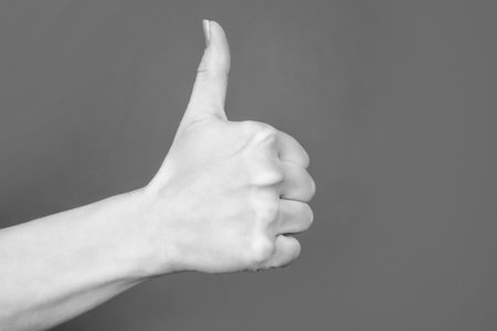 female hand showing thumb up gesture on red background