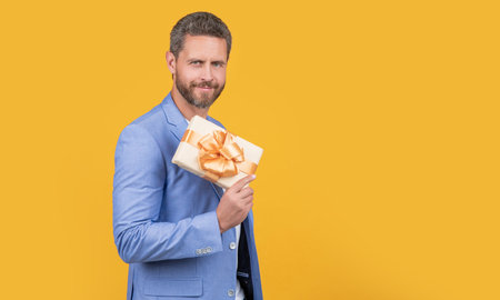 positive guy hold present box in studio. guy with present box for holiday. photo of guyの写真素材