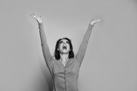 Happy girl in fashion pink sweater keeping open hands raised for copy space, presenting productの写真素材