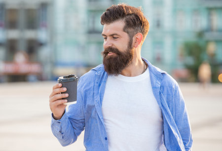 photo of guy smile at coffee break. guy at coffee break outdoor. guy at coffee break outside.の写真素材