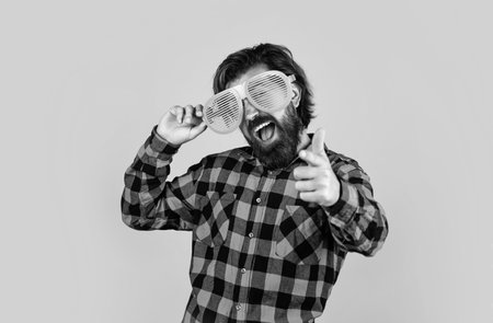 bearded man in checkered shirt and party glasses. funny guy express human emotions. happy hipster with long hair and moustache having fun. male is going on summer vacationの写真素材