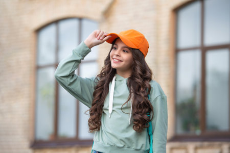 photo of happy casual teen girl childhood in cap. casual teen girl childhood outdoor.