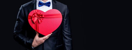 cropped view of tuxedo man with proposal valentine gift. photo of tuxedo man hold proposal giftの写真素材