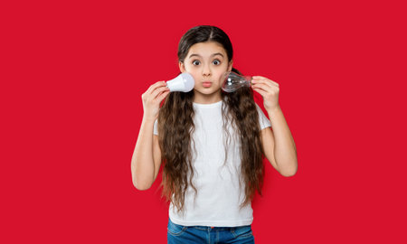 funny teen girl with lightbulb isolated on red. teen girl with lightbulb in studio.
