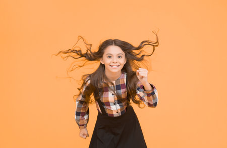 Cant be stopped. Active child run to school. Happy girl back to school. Active childhood. Health and emotions. Healthy development and growth. Active lifestyle. Active and energeticの写真素材