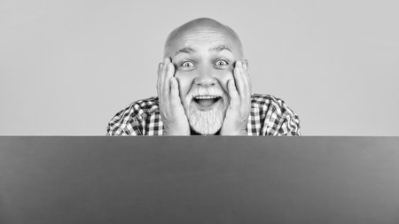 amazed happy senior man with copy space on blank bannerの写真素材