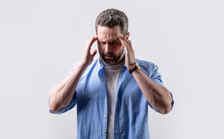 mature man suffer from headache and migraine in studio. photo of man with migraine headacheの写真素材