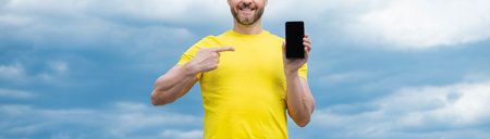 cropped view of man presenting screen of smartphone with copy space. pointing finger