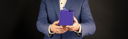 cropped man in tuxedo bow tie formalwear on black background hold box. birthdayの写真素材