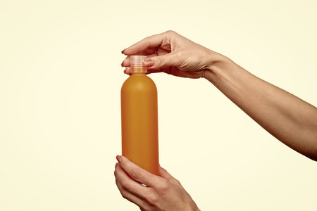 female hands hold cosmetic bottle with copy spaceの写真素材