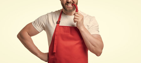 cropped view of man in apron with chili vegetable isolated on whiteの写真素材