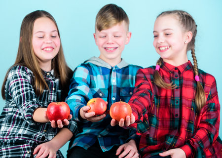 Promoting healthy nutrition. Group teenagers cheerful kids hold apples. Boy and girls friends eat apple. Teens with healthy snack. Healthy dieting and vitamin nutrition. Eat fruit and be healthyの写真素材